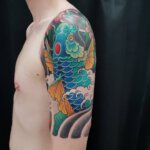 Oberarm Tattoo mit blauem Koi