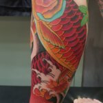 Bein Tattoo mit rotem Koi als Motiv