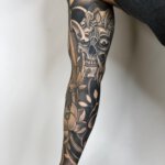 Arm Tattoo mit Totenkopf & Blumen Motiv