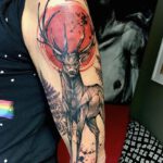 Arm Tattoo auf dem ein Hirsch unter einem roten Mond abgebildet ist