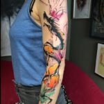 Bunter Drache mit Krone als Arm Tattoo
