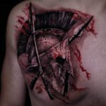 Brust Tattoo als Motiv ein römischer Helm mit roten Farbverläufen